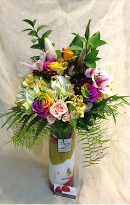 Ανθοπωλείο . Μπουκέτο με άνθη εποχής σε  γυάλινο βάζο με στρώσεις χρωματιστής διακοσμητικής άμμου - Special