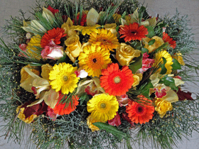 Basket with multi colored flowers and winter greens