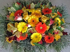 Basket with multi colored flowers and winter greens