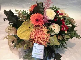 Flowers & dried oak leaves in basket. Autumn flavor arrangement.