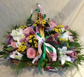 Basket with multi colored flowers and winter greens