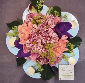 Flower arrangement on metal plate (diam.25cm) with sea pebbles