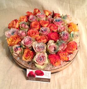 Πολύχρωμα τριαντάφυλλα σε βάζο  με διακόσμηση χρωματιστής άμμου.