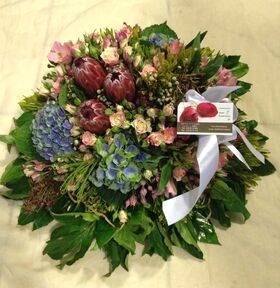 Condolences arrangement with exclusive tropical and seasonal flowers