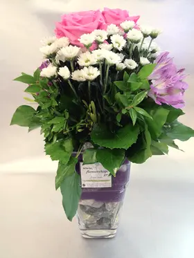 Pebbles  in glass vase with season summer flowers