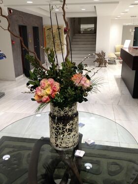 Exclusive arrangement in design vase. (flowers selected upon season and theme)
