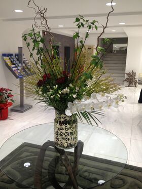 Exclusive arrangement in design vase. (flowers selected upon season and theme)