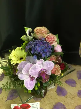 Exclusive season flowers in glass tray arrangement