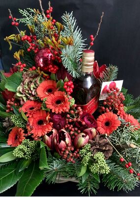 Christmas arrangement in a basket with chocolates and drinks