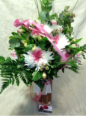 Ανθοπωλείο . Μπουκέτο με άνθη εποχής σε  γυάλινο βάζο με στρώσεις χρωματιστής διακοσμητικής άμμου