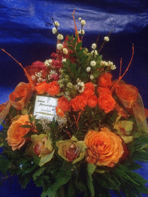 Ανθοπωλεία.Σύνθεση σε καλάθι με πορτακαλί  λουλούδια εποχής