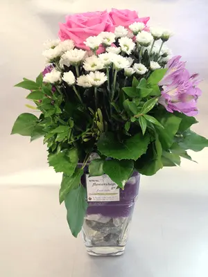 Pebbles  in glass vase with season summer flowers