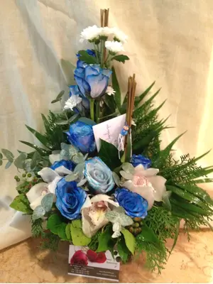 Arrangement with blue colored roses.
