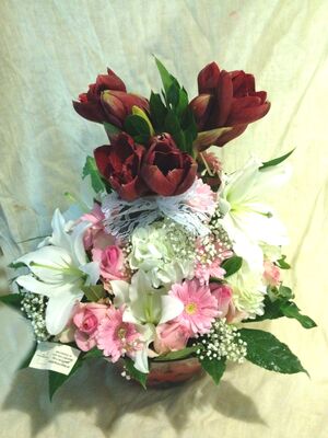 Flower arrangement in glass cube  vase with decorative colored sand layers