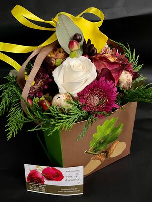 Flower arrangement with flowers in decorative hand paper bag.