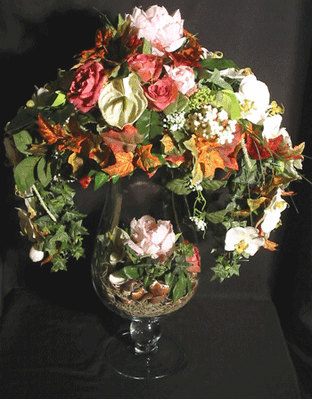 Artificial flower arrangement in big champagne glass