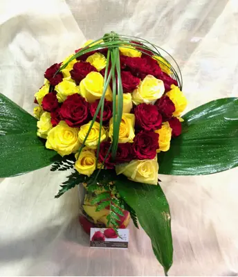 Roses (70) stems in vase with colored water and rose pedals.