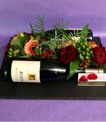 Flower arrangement on tray. (2) Bottles of wine.