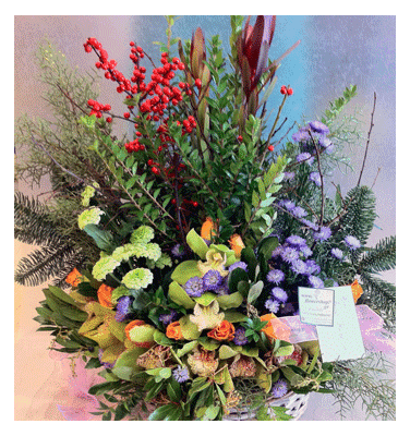 Flower arrangement in basket with season flowers and relative greens