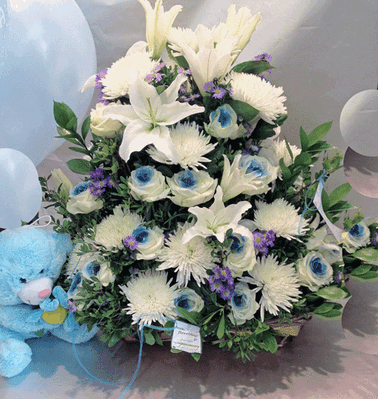 Σύνθεση με λουλούδια σε καλάθι με μπαλόνια και αρκούδο.
