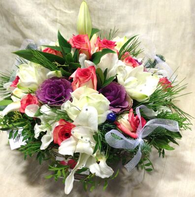 White flowers and christmas greens in basket with accessories