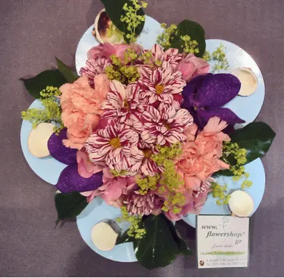 Flower arrangement on metal plate (diam.25cm) with sea pebbles