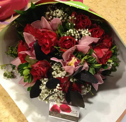 (20) red roses A' quality Dutch gift wrapped with greens.Special with cymbidium orchids.