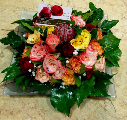 Ανθοπωλεία. Σύνθεση με πολύχρωμα τριαντάφυλλα σε δίσκο.