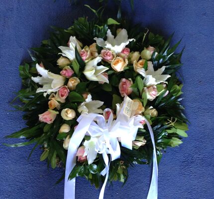 Στεφάνι με λευκά ή ροζ λουλούδια.