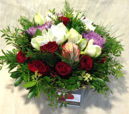 Σύνθεση λουλουδιών σε καλάθι με λουλούδια και χειμερινές πρασινάδες