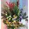 Flower arrangement in basket with season flowers and relative greens