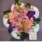 Flower arrangement on metal plate (diam.25cm) with sea pebbles
