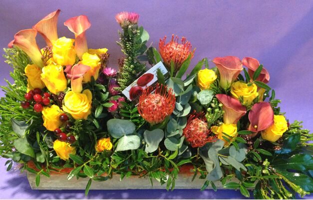Exclusive flower arrangement on tray with colored block moss.