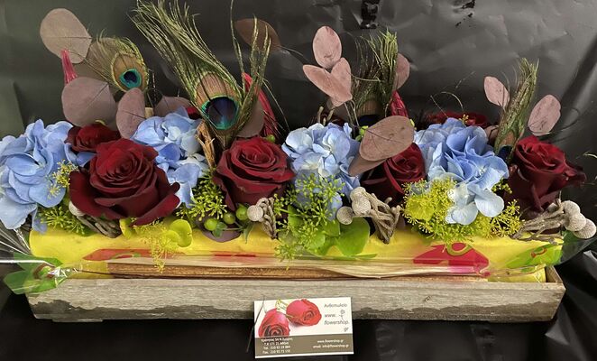 Exclusive flower arrangement on tray with colored block moss.